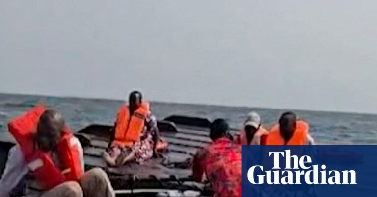 Rescued passengers on the capsized hull of a ferry on Lake Kariba, Zimbabwe.