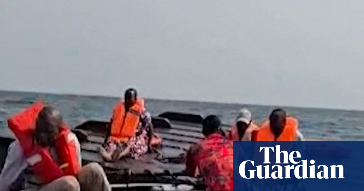Rescued passengers on the capsized hull of a ferry on Lake Kariba, Zimbabwe.