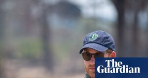Prince Harry wearing a cap and sunglasses in an African national park.