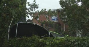 A damaged trampoline tangled in tree branches after a severe storm in Repentigny, Quebec, under investigation for a possible tornado.