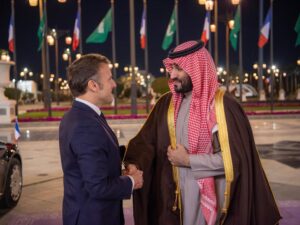 French President Emmanuel Macron and Saudi Crown Prince Mohammed bin Salman shaking hands at a formal meeting.