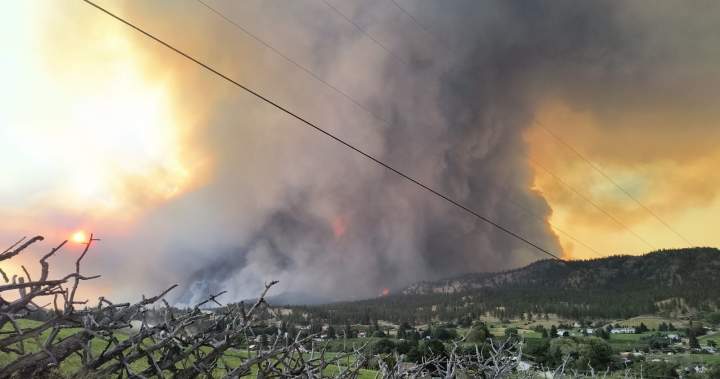 An aerial photo of the Bald Range wildfire approaching Summerland, BC, showing a red evacuation zone map.