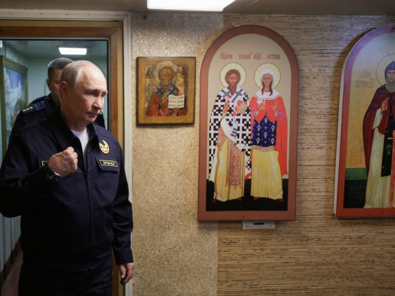 Russian President Vladimir Putin on a naval cruiser, overseeing drills amidst threats of vessel seizures.