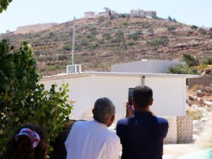Qusra Mayor Abdulatheem Wadi points at Palestinian houses besieged by Israeli settlers in the West Bank.