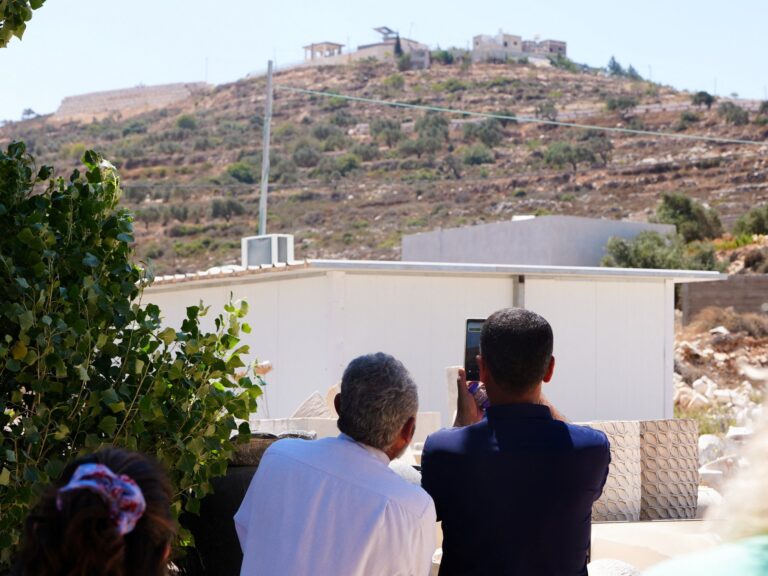 Qusra Mayor Abdulatheem Wadi points at Palestinian houses besieged by Israeli settlers in the West Bank.
