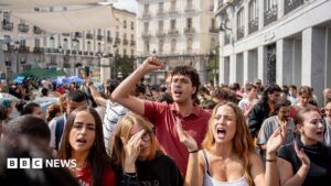 Protesters in Madrid gathering during the housing crisis, demanding legislative change against evictions.