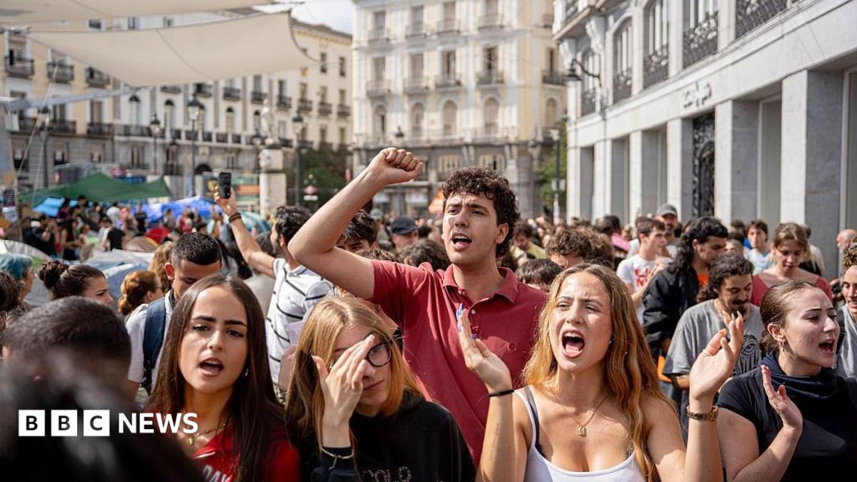 Protesters in Madrid gathering during the housing crisis, demanding legislative change against evictions.
