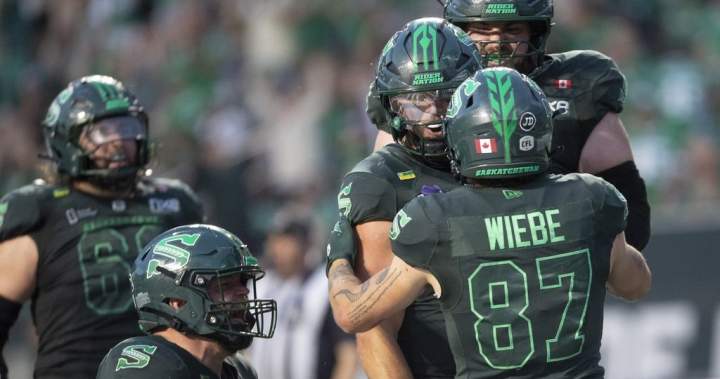 Saskatchewan Roughriders quarterback Tommy Stevens is embraced by Daniel Wiebe after scoring a touchdown.