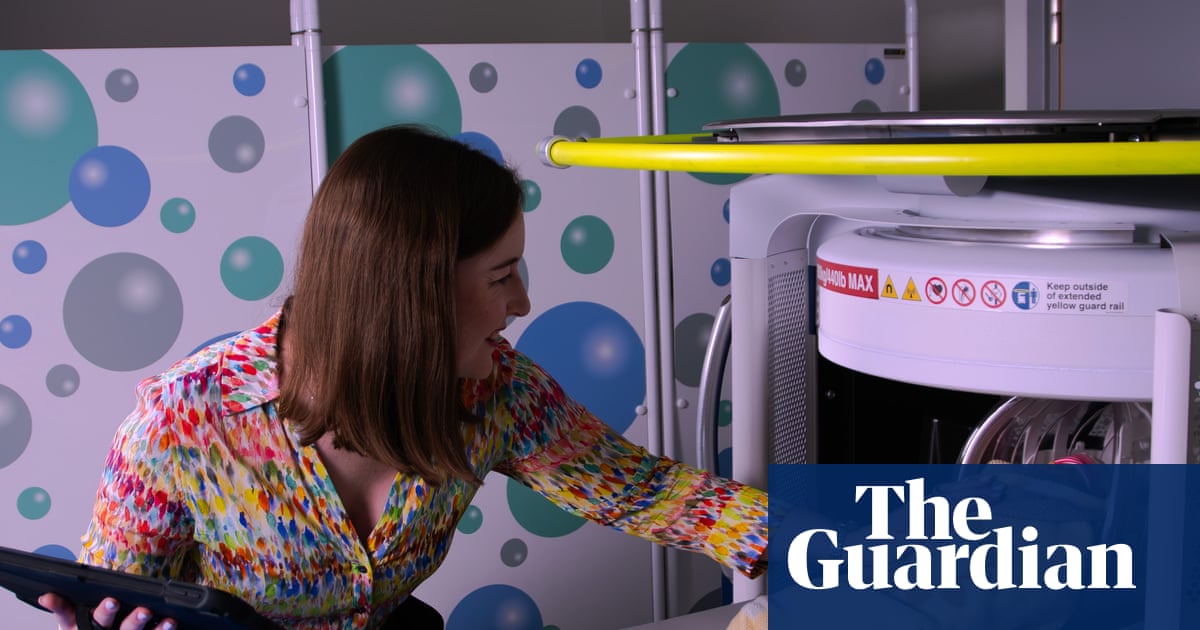 Researcher next to an MRI machine with a swaddled baby inside, illustrating a study on anaemia in pregnancy and brain development.