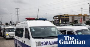 Ambulance stuck in traffic in Lagos, Nigeria, highlighting transport challenges during a health crisis.