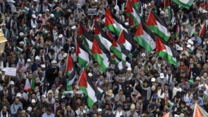 Protestors in Morocco waving flags and demonstrating against diplomatic ties with Israel.