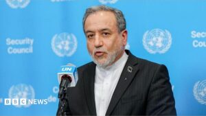 An Iranian diplomat speaking at a podium regarding the potential reopening of the Strait of Hormuz.