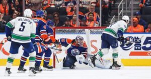 Paul Cotter celebrates his overtime goal during the Canucks and Oilers season opener.