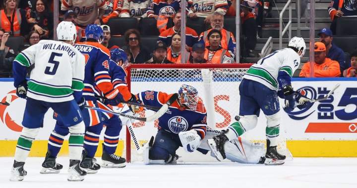 Paul Cotter celebrates his overtime goal during the Canucks and Oilers season opener.