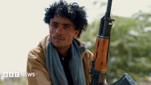 A soldier stands on a mountain ridge in Yemen observing the front line near Taiz as the civil war continues.